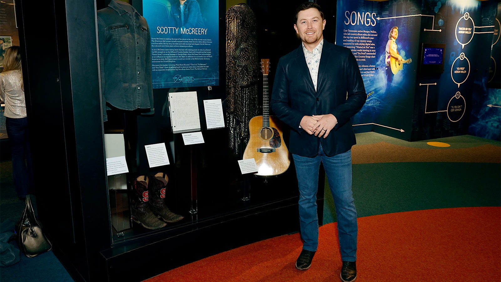 Music star Scotty McCreery at the Country Music Hall of Fame's American Currents exhibit, standing next to a display about him.